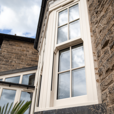 external view of a cream sliding sash window installed by alexnader windows in new mills