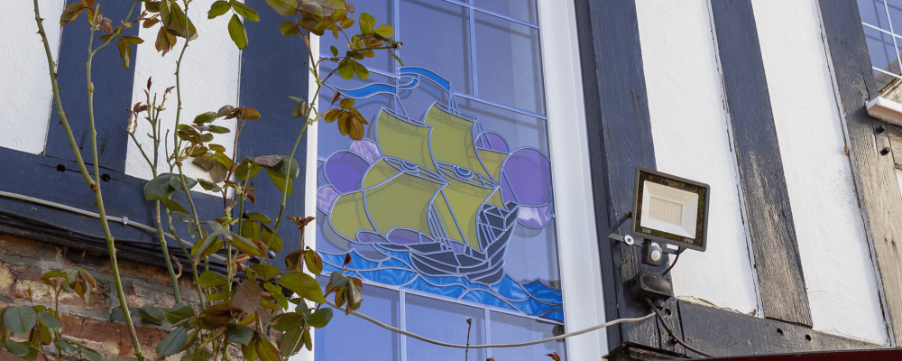 close up of the stained glass ship design that has been re-created by alexander windows at davenport residential home in stockport