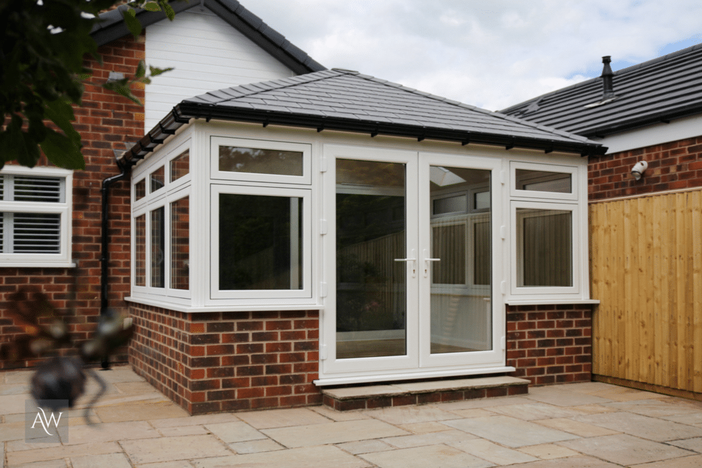 Guardian Warm Roof conservatory installed by Alexander Windows. Photograph is an external view showing the replacement roof, windows & doors.