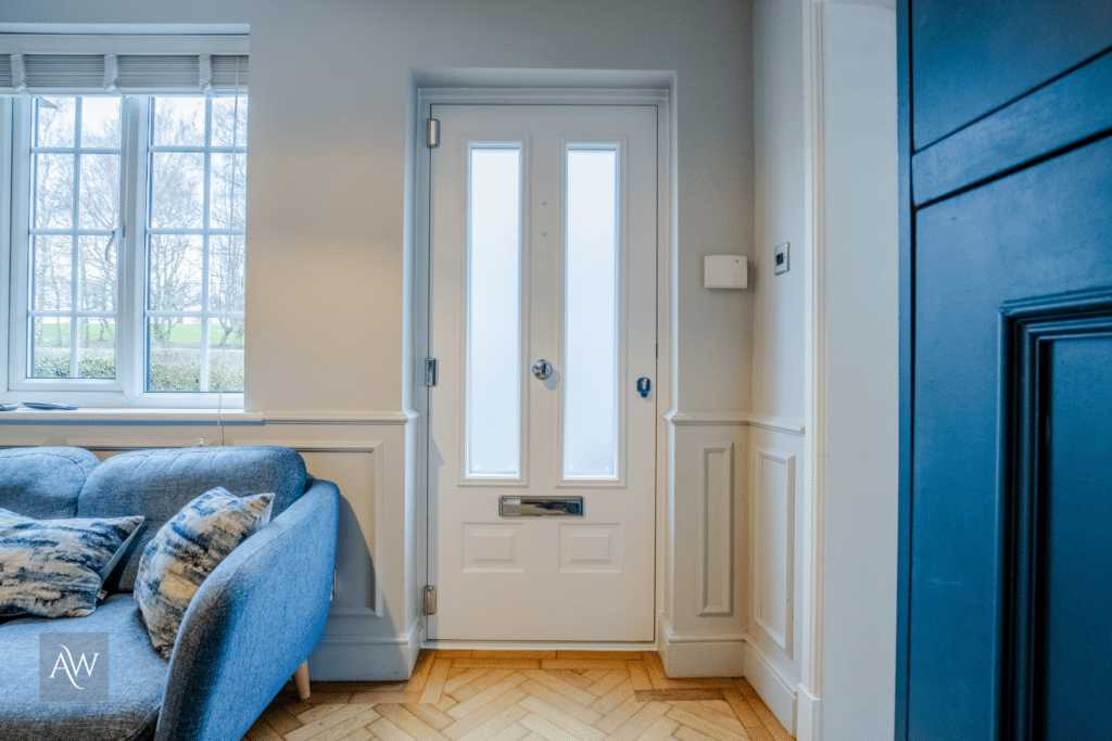 installation of a solidor edinburgh composite door by alexander windows. Photograph shows the internal view of the door which is white with a matching internal frame.